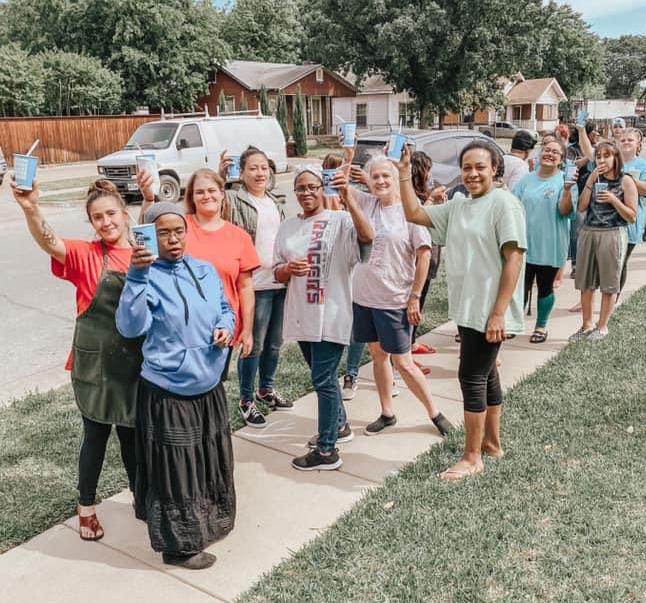 Women from the Home walking together outdoors, waving.